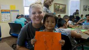Young Adults Ministry Servant Event participant interacts plays with a refugee child at a Christian Friends of New Americans event. 