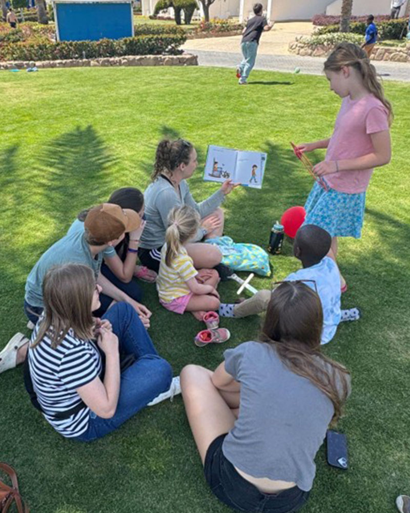 Some of the kids enjoyed kicking the soccer ball around during our outdoor time, while others enjoyed hearing a story in the shade. (Trisha Festerling)